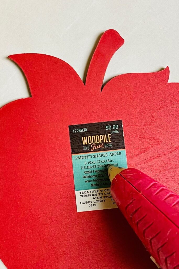 putting hot glue on apple wooden cutout 