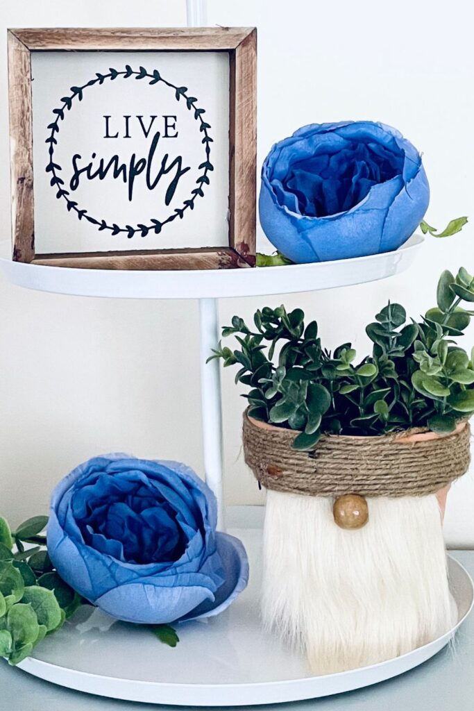 flower pot gnome on shelving with faux flowers 